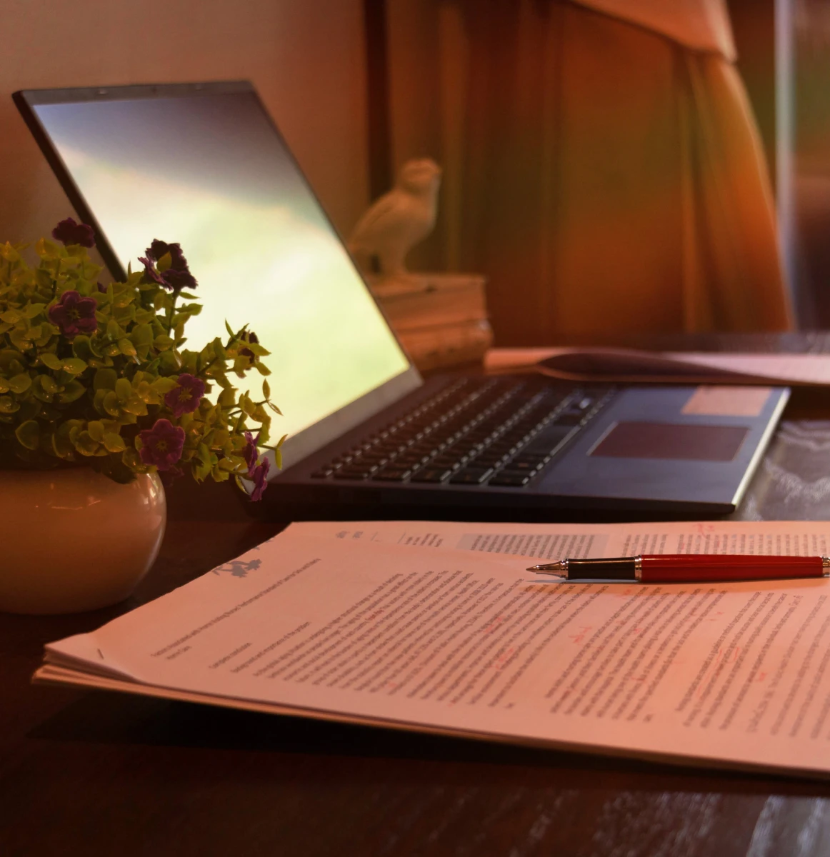 Laptop and documents on a wooden desk