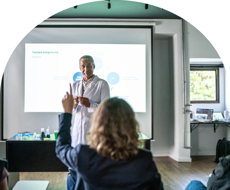 Audience member raising hand in lecture