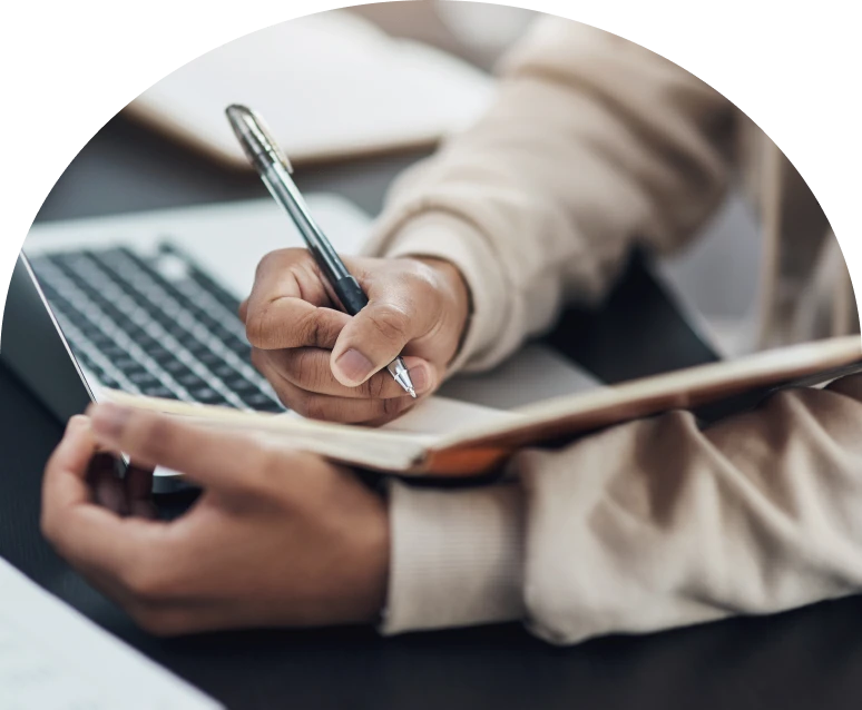 Hand holding pen, taking notes on clipboard